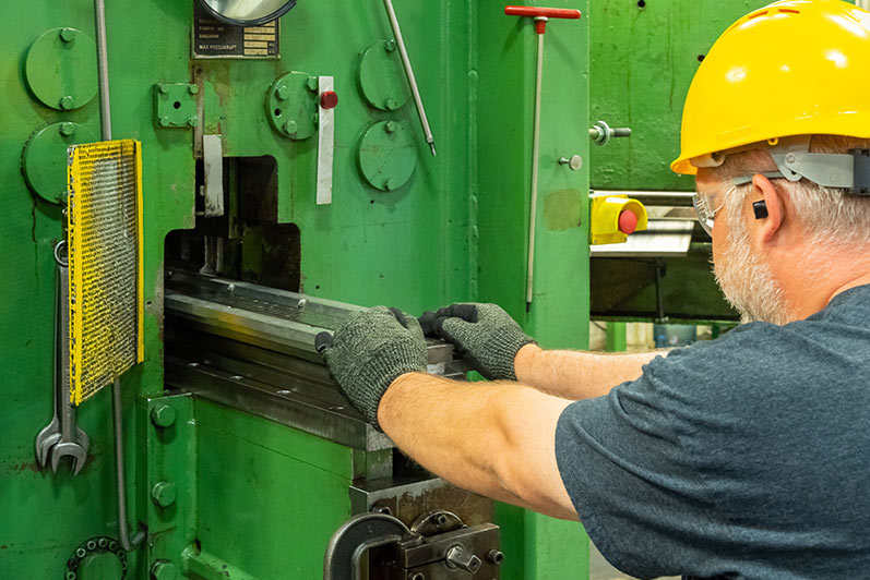 Operator setting up perforating machine